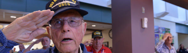 Coast Guard veteran salutes with fellow veterans